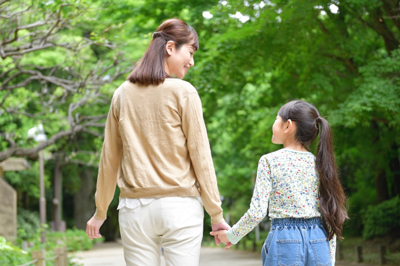 母親と子供が手をつなぎ散歩している